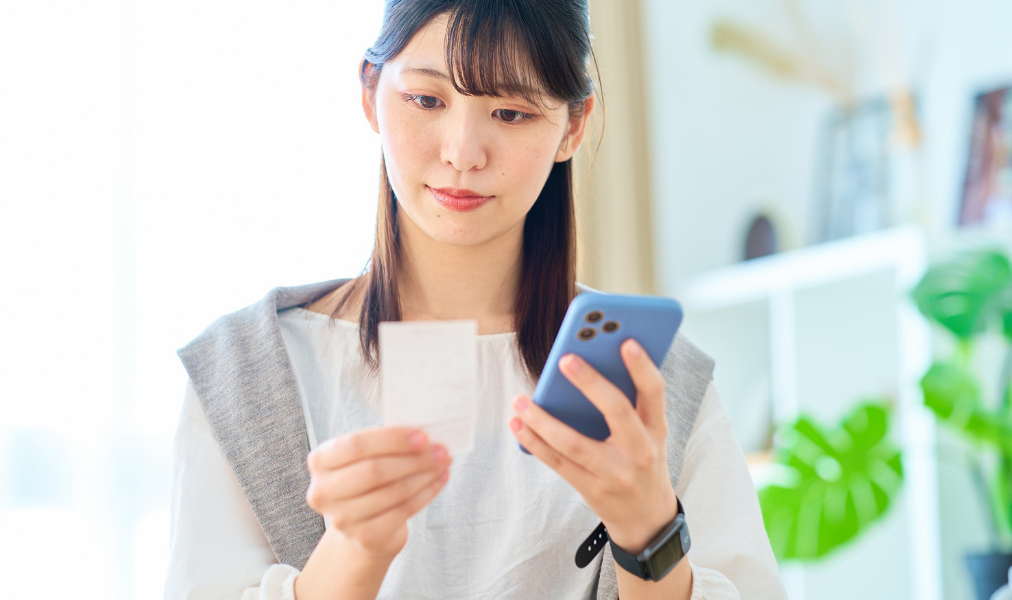 レシートを見ながらスマートフォンで確認する利用シーン